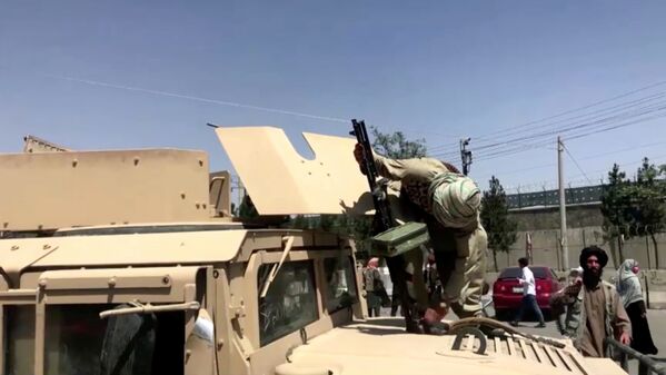 مقاتل من طالبان  يثبت رشاشا على ناقلة جند مدرعة بالقرب من مطار كابول - سبوتنيك عربي