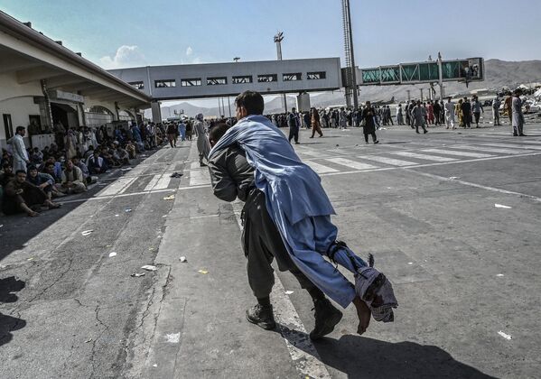 متطوع ينقل جريح أفغاني في مطار كابول - سبوتنيك عربي
