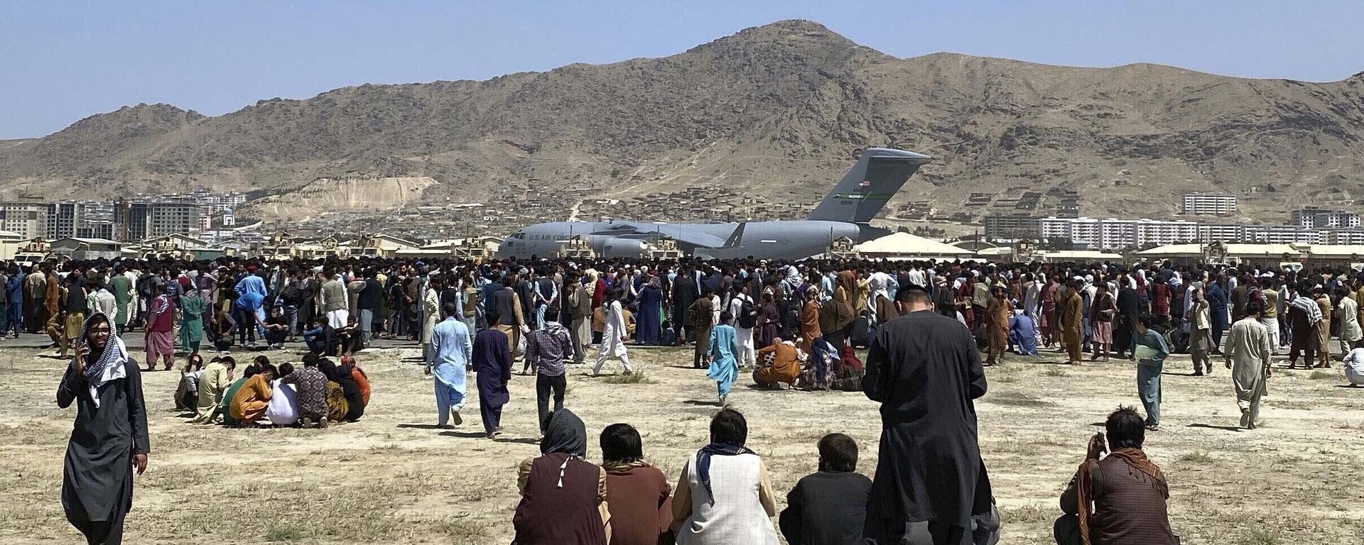 في 16 أغسطس 2021، صورة ملف تجمع مئات الأشخاص بالقرب من طائرة نقل تابعة للقوات الجوية الأمريكية من طراز سي-17، على طول محيط المطار الدولي في كابول، أفغانستان. - سبوتنيك عربي, 1920, 26.08.2021
