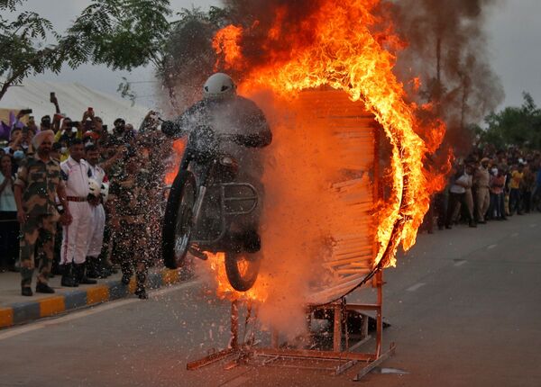 جندي من قوة حراسة الحدود ينفذ حركة بلهوانية على دراجته النارية خلال عرض على الطريق للاحتفال بمرور 75 عامًا على استقلال الهند، في أحمد أباد، الهند، 25 أغسطس 2021 - سبوتنيك عربي