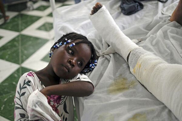 يونيكا ترقد بجانب والدتها جيرثا يليت، التي أصيبت في الزلزال قبل أسبوع واحد، في مستشفى الحبل بلا دنس، المعروف أيضًا باسم المستشفى العام في ليس كاي، هايتي، 22 أغسطس2021 - سبوتنيك عربي