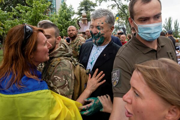 الرئيس الأوكراني السابق بيترو بوروشينكو يتحدث مع أحد أنصاره بعد أن رشه مهاجم بسائل أخضر خلال حدث بمناسبة عيد الاستقلال في كييف، أوكرانيا، 24 أغسطس 2021 - سبوتنيك عربي