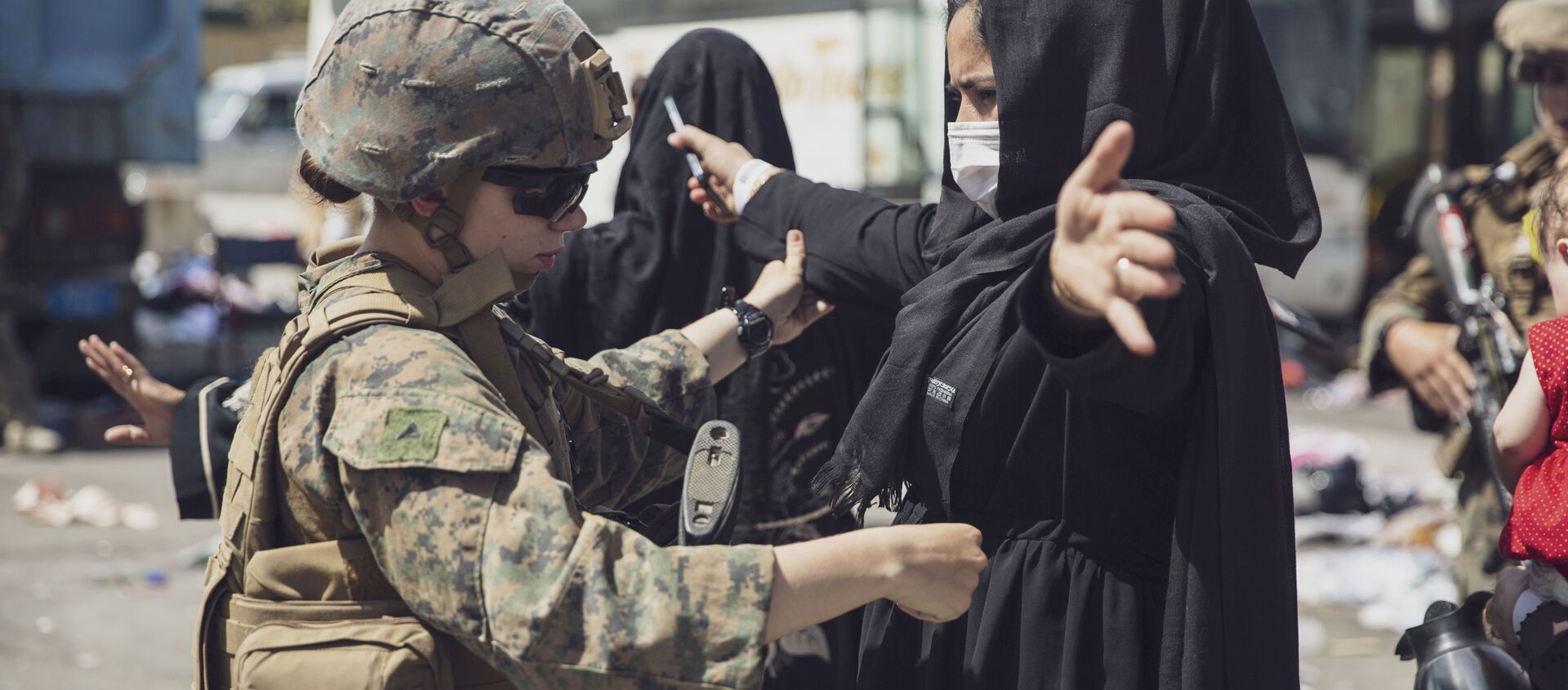 جندية أمريكية تقوم بفحص امرأة أفغانية قبل الإجلاء من مطار حامد كرزاي الدولي في كابول، أفغانستان 28 أغسطس 2021 - سبوتنيك عربي, 1920, 30.08.2021
