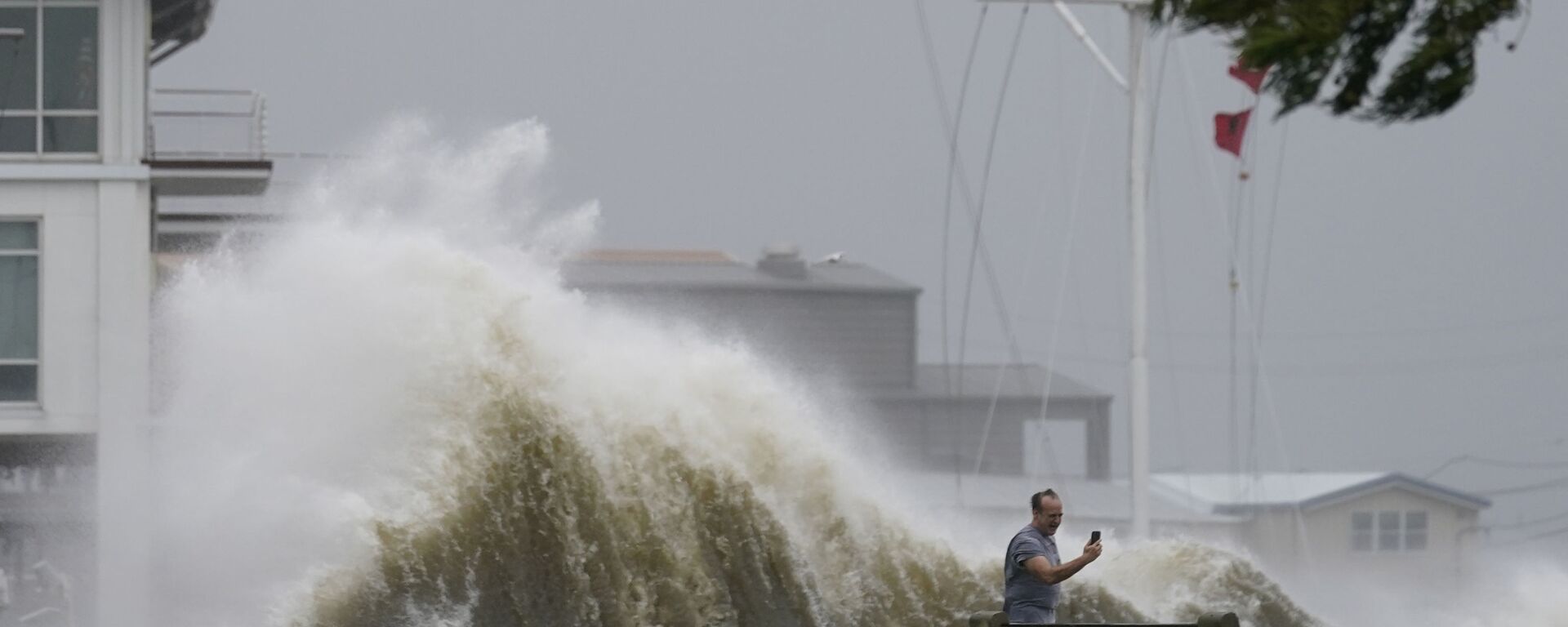 رجل يلتقط صوراً للأمواج العالية على طول شاطئ بحيرة بونتشارترين مع اقتراب إعصار إيدا، في نيو أورلينز 29 أغسطس 2021 - سبوتنيك عربي, 1920, 25.09.2021