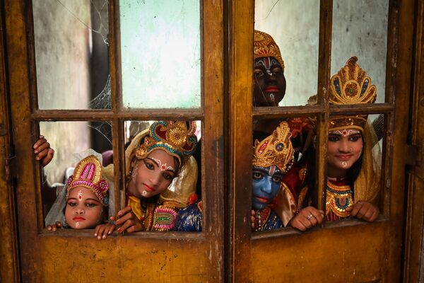 فنانون يرتدون أزياء الإله الهندوسي كريشنا ورفاقه الأسطوريين، وهم ينتظرون بدء مهرجان جانماشتامي للاحتفال بميلاد اللورد كريشنا في كولكاتا، الهند في 30 أغسطس 2021 - سبوتنيك عربي