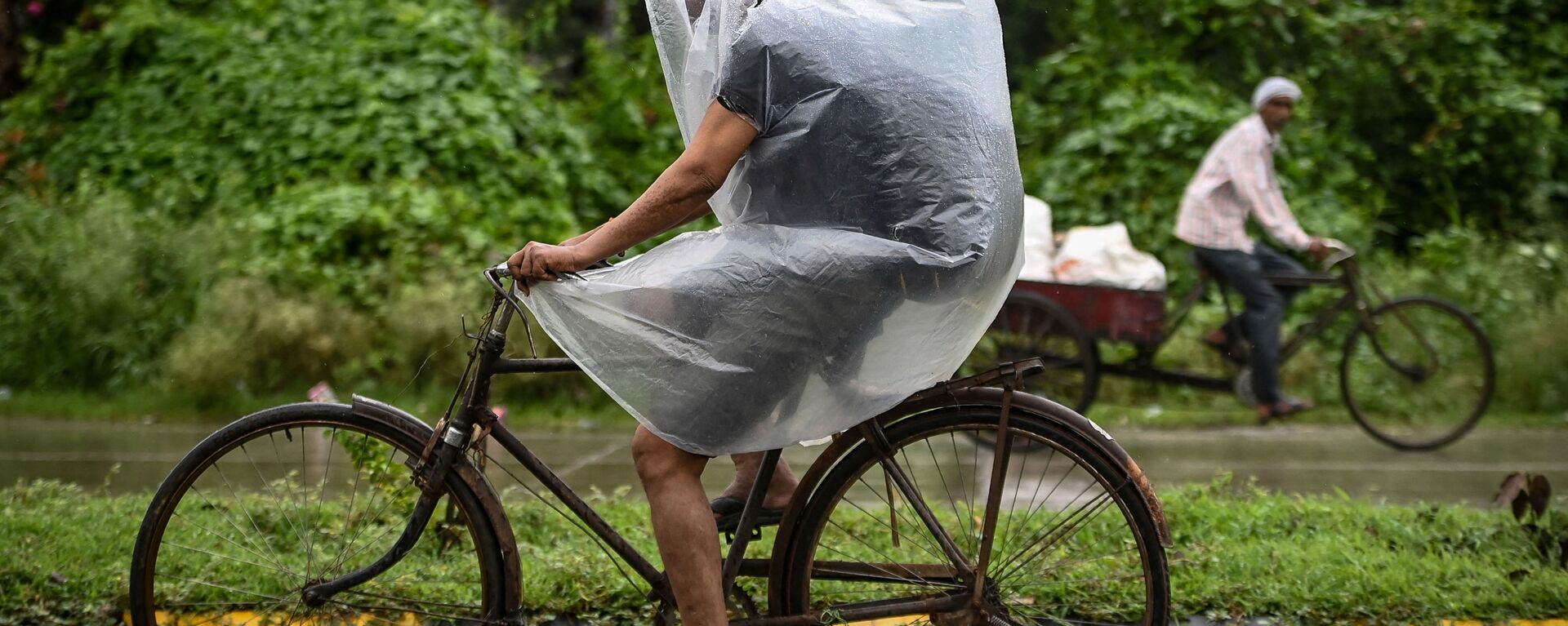 راكب دراجة يغطي نفسه بغطاء بلاستيكي أثناء هطول أمطار غزيرة في فريد آباد، الهند 1 سبتمبر 2021 - سبوتنيك عربي, 1920, 19.06.2022