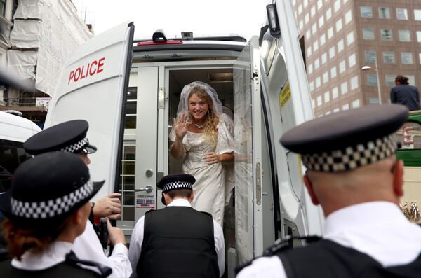 ناشطة ترتدي فستان زفاف وهي تقف في سيارة الشرطة خلال احتجاج تمرد الانقراض في لندن، بريطانيا، 31 أغسطس 2021
 - سبوتنيك عربي