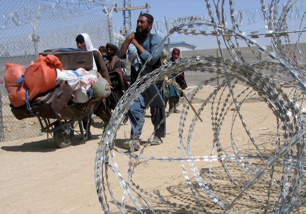 عائلة قادمة من أفغانستان تشق طريقها عبر نقطة عبور بوابة الصداقة في بلدة شامان الحدودية الباكستانية الأفغانية، باكستان، 19 أغسطس 2021 - سبوتنيك عربي