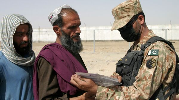 جندي باكستاني يتحقق من وثائق الأشخاص القادمين من أفغانستان عند نقطة عبور بوابة الصداقة في بلدة شامان الحدودية بين باكستان وأفغانستان، باكستان، 27 أغسطس 2021 - سبوتنيك عربي