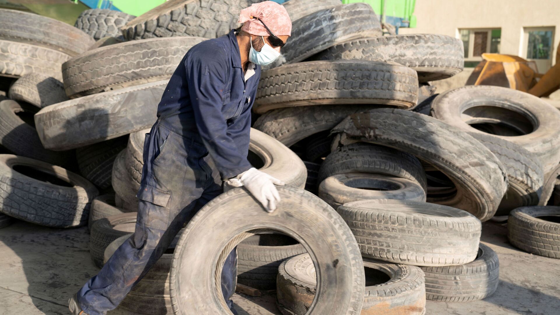 صورة لعامل في EPSCO Global General Trading وهو يستعد لإعادة تدوير إطار في مصنع إعادة تدوير الإطارات في منطقة السالمي، الكويت، 1 سبتمبر 2021 - سبوتنيك عربي, 1920, 21.01.2022
