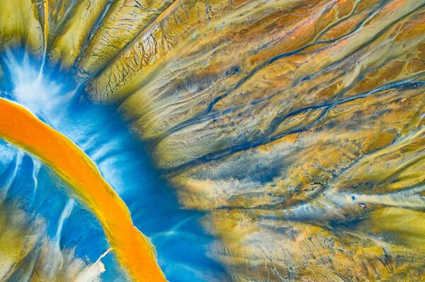 صورة بعنوان النهر المسمم، للمصور غيورغي بوبا، الفائز بالمركز الأول في فئة التصوير التجريدي من مسابقة التصوير بواسطة الدرون لعام 2021

هذه صورة مفصلة لأحد الأنهار الصغيرة التي انتشر السم في مياهها. الجمال المسموم هو مشروع شخصي للمصور يروي فيه قصة الكارثة الطبيعية في جبال ابسيني، ولكن بطريقة تجريدية جميلة. تم إنشاء هذا النمط الملون المجرد بواسطة الطبيعة جنبًا إلى جنب مع النفايات الكيميائية الناتجة عن عملية تعدين النحاس والذهب. - سبوتنيك عربي