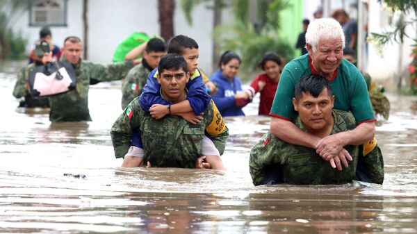 أفراد من الجيش المكسيكي ينقذون الأشخاص الذين حوصروا في منازل غمرتها المياه بعد هطول أمطار غزيرة في تلاكيباك، بولاية خاليسكو، المكسيك، 3 سبتمبر 2021 - سبوتنيك عربي
