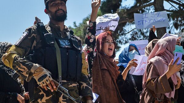 نساء أفغانيات يرددن شعارات بجانب أحد مسلحي حركة طالبان خلال مظاهرة مناهضة لباكستان بالقرب من السفارة الباكستانية في كابول، أفغانستان 7 سبتمبر 2021 - سبوتنيك عربي