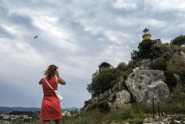 فتاة تلتقط صورة لمنارة في أعلى القلعة القديمة لمدينة كركيرا في جزيرة كورفو اليونانية - سبوتنيك عربي