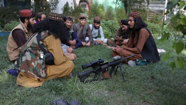 مسلحون من طالبان يجلسون على العشب في أحد المتنزهات الترفيهية في مدينة كابول، أفغانستان، 13 سبتمبر 2021 - سبوتنيك عربي