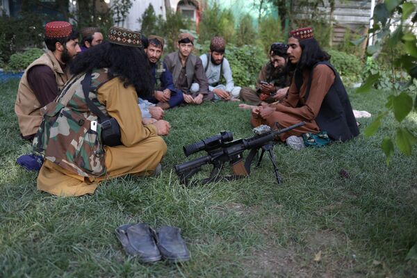 مسلحون من طالبان يجلسون على العشب في أحد المتنزهات الترفيهية في مدينة كابول، أفغانستان، 13 سبتمبر 2021 - سبوتنيك عربي