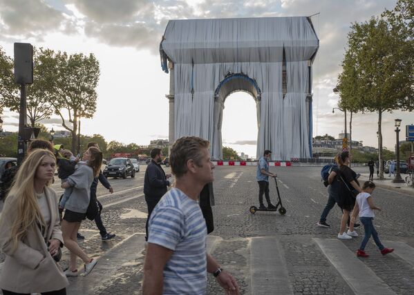 مواطنون يعبرون الطريق بالقرب من قوس النصر في وقت مبكر من يوم الأحد في باريس، 12 سبتمبر 2021

حيث من المقرر عرض مشروع L'Arc de Triomphe، Wrapped للفنان الراحل كريستو وجين كلود في الفترة من 18 سبتمبر/ أيلول إلى 3 أكتوبر/ تشرين الأول. سيتم تغطية النصب التذكاري الشهير في باريس بمساحة 25000 متر مربع من القماش باللون الأزرق الفضي، وبها 3000 متر من الحبل الأحمر. - سبوتنيك عربي