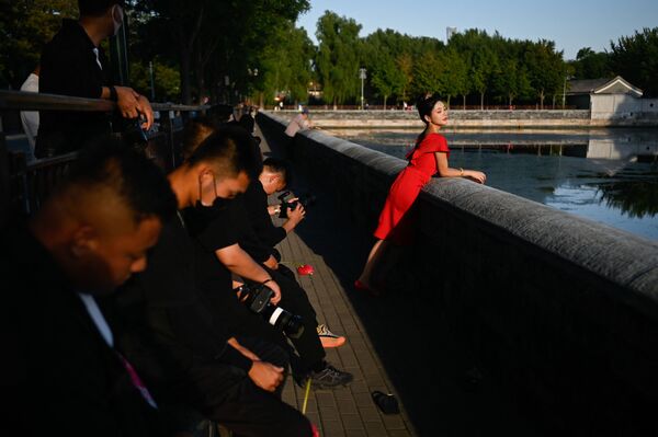 امرأة تقف لالتقاط صورة زفاف خارج المدينة المحرمة في بكين في 22 سبتمبر 2021. - سبوتنيك عربي
