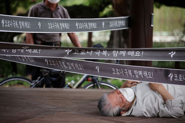 رجل يستريح في جناح تم تطويقه كإجراء لتجنب انتشار مرض فيروس كورونا (كوفيد-19) في حديقة في سيؤل، كوريا الجنوبية، 27 سبتمبر 2021. - سبوتنيك عربي