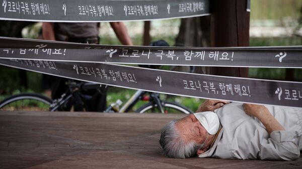 رجل يستريح في جناح تم تطويقه كإجراء لتجنب انتشار مرض فيروس كورونا (كوفيد-19) في حديقة في سيؤل، كوريا الجنوبية، 27 سبتمبر 2021. - سبوتنيك عربي