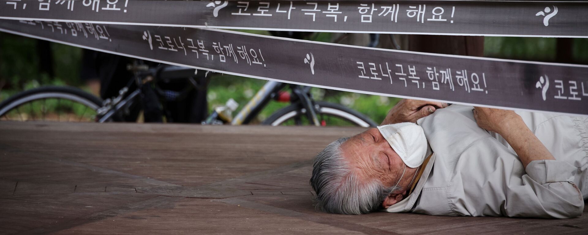 رجل يستريح في جناح تم تطويقه كإجراء لتجنب انتشار مرض فيروس كورونا (كوفيد-19) في حديقة في سيؤل، كوريا الجنوبية، 27 سبتمبر 2021. - سبوتنيك عربي, 1920, 26.11.2021