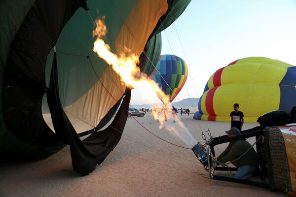طاقم يقوم بإعداد المنطاد قبل الإقلاع خلال مهرجان منطاد الهواء الساخن في صحراء وادي رم، الأردن، 1 أكتوبر 2021. - سبوتنيك عربي