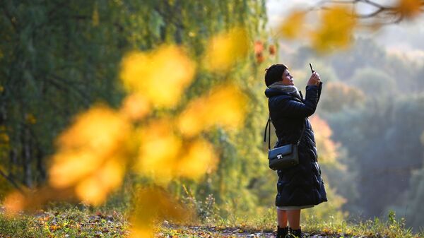 امرأة تلتقط الصور لأشجار الخريف في إحدى حدائق موسكو، روسيا 4 أكتوبر 2021 - سبوتنيك عربي