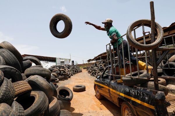 عامل يفرغ إطارات سيارات من شاحنة استعدادًا لإعادة التدوير في مصنع إعادة تدوير نفايات فريتاون في إبادان، نيجيريا، 17 سبتمبر 2021 - سبوتنيك عربي