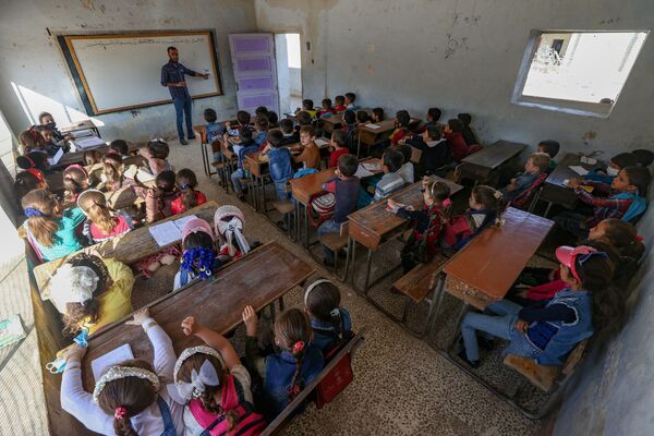 أطفال أثناء حضورهم اليوم الأول من المدرسة في قرية في ريف إدلب شمال غرب سوريا، 9 أكتوبر 2021. - سبوتنيك عربي