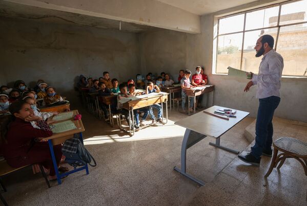 أطفال يحضرون اليوم الأول من المدرسة في قرية بريف إدلب شمال غرب سوريا، 9 أكتوبر 2021. - سبوتنيك عربي