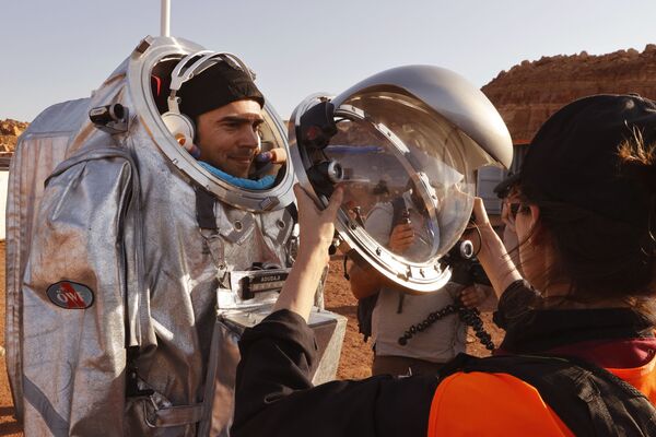 تقنيون يساعدون رواد الفضاءعلى ارتداء زي رائد فضاء، أثناء التدريب في موقع يحاكي محطة فضاء في حفرة رمون في متسبي رمون في صحراء النقب جنوب إسرائيل، 10 أكتوبر 2021. - سبوتنيك عربي