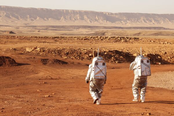 رواد فضاء من فريق من أوروبا وإسرائيل يرتدون بدلات فضائية خلال مهمة تدريبية لكوكب المريخ، في موقع يحاكي محطة خارج الموقع في حفرة رامون في متسبي رمون في صحراء النقب جنوب إسرائيل في 10 أكتوبر 2021. - سبوتنيك عربي