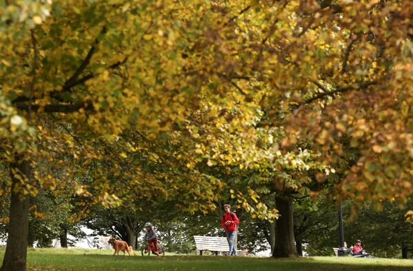 يسير الناس عبر تل تريمورس هيل حيث تبدأ الأشجار في إظهار ألوانها الخريفية في لندن، بريطانيا، 10 أكتوبر 2021. - سبوتنيك عربي