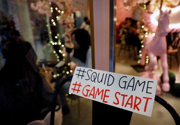 لافتة مكتوب عليها فلتبدأ اللعبة على باب مقهى براون باتر لبيع حلوى البسكويت (Honeycomb) من طفولة الكوريين التي كانت ضمن مسلسل لعبة الحبّار (Squid Game) المعروض على شبكة نتفليكس، في سيؤل، كوريا الجنوبية، 1 أكتوبر 2021. - سبوتنيك عربي