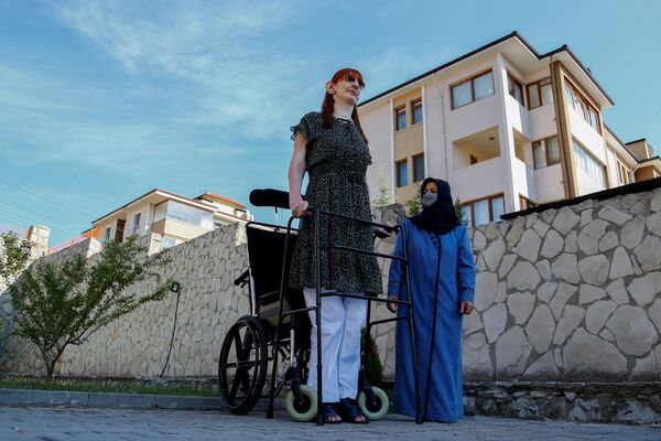 أطول امرأة في العالم، روميسا جيلجي، تقف مع والدتها صفية جيلجي، خلال مؤتمر صحفي خارج منزلهم في سافرانبولو، مقاطعة كارابوك، تركيا، 14 أكتوبر 2021. - سبوتنيك عربي