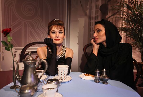 زائرة تجلس بجوار تمثال شمعي للممثلة الأمريكية الشهيرة أودري هيبورن، في متحف مدام توسو دبي، الإمارات العربية المتحدة، 13 أكتوبر 2021 - سبوتنيك عربي