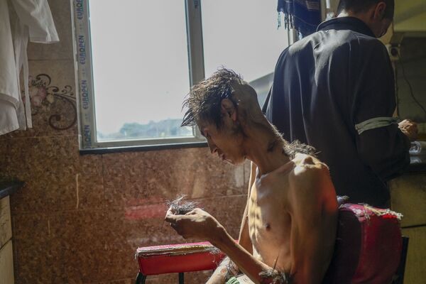 حلاقة شعر أحد المدمنين في مستشفى ابن سينا الطبي للعلاج من تعاطي المخدرات في كابول، أفغانستان 16 أكتوبر 2021 - سبوتنيك عربي