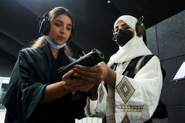 مدربة الأسلحة النارية السعودية، منى الخريص، تعلّم فتاة سعودية الاستخدام الآمن للأسلحة في ميدان الرماية Top-Gun في الرياض، المملكة العربية السعودية، 28 أكتوبر 2021 - سبوتنيك عربي