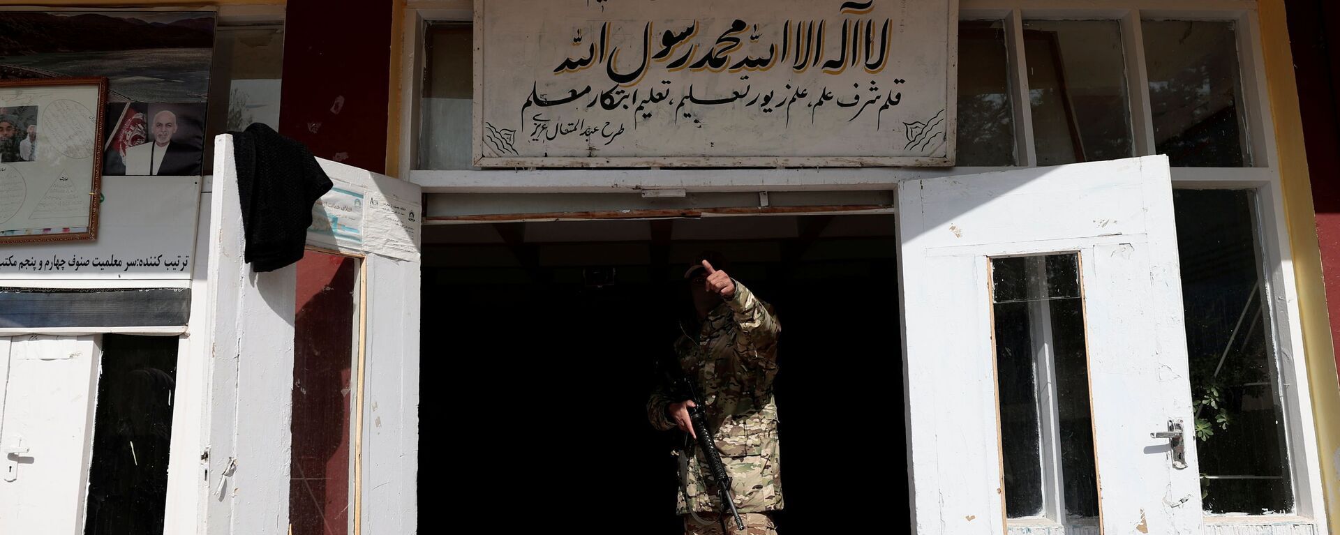مقاتل من طالبان يشير إلى زميل له وهو يقف عند مدخل مدرسة في كابول، أفغانستان، 25 أكتوبر 2021 - سبوتنيك عربي, 1920, 17.11.2021