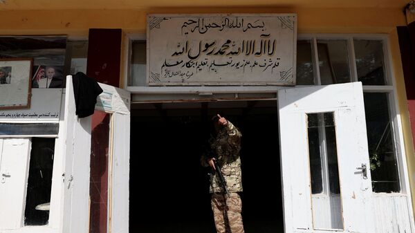 مقاتل من طالبان يشير إلى زميل له وهو يقف عند مدخل مدرسة في كابول، أفغانستان، 25 أكتوبر 2021 - سبوتنيك عربي