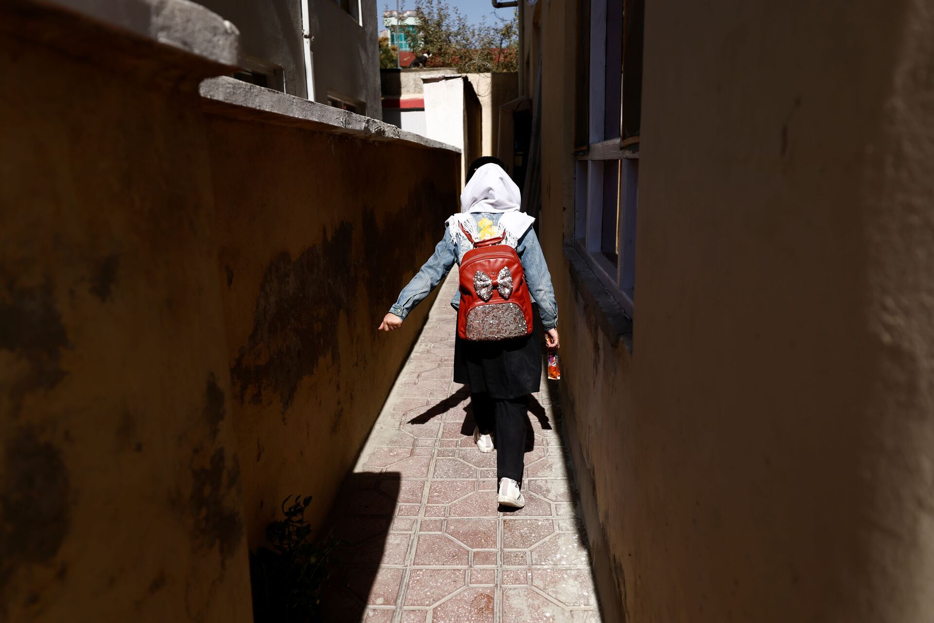 هادية، 10 أعوام، طالبة في الصف الرابع الابتدائي، تعود من المدرسة عبر زقاق بالقرب من منزلها في كابول، أفغانستان، 20 أكتوبر2021. - سبوتنيك عربي, 1920, 23.11.2021