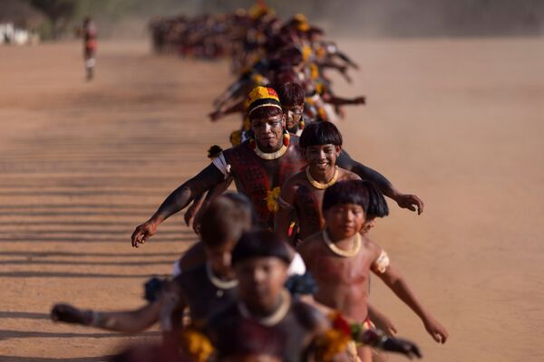 رجال قبيلة ياوالابيتي (Yawalapiti) يؤدون رقصة الحداد خلال كواروب (Kuarup)، وهي طقوس جنائزية لتكريم ذكرى Cacique Aritana ، زعيم ياوالابيتي، في حديقة شينغو الوطنية، البرازيل، 4 سبتمبر 2021. - سبوتنيك عربي