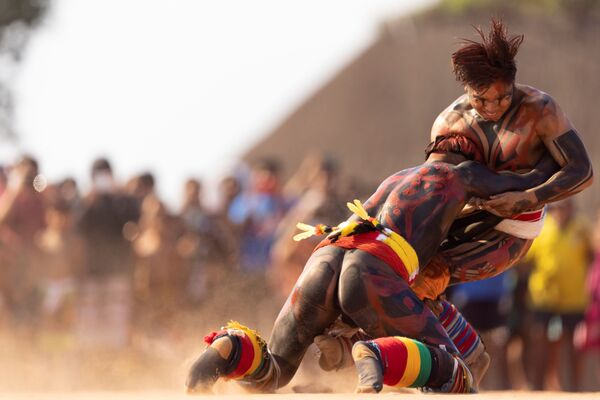 رجال من قبائل مختلفة يشاركون في مصارعة ضمن طقوس كواروب (Kuarup)، وهي طقوس جنائزية لتكريم ذكرى Cacique Aritana ، زعيم ياوالابيتي، في حديقة شينغو الوطنية، البرازيل، 10 سبتمبر 2021. - سبوتنيك عربي