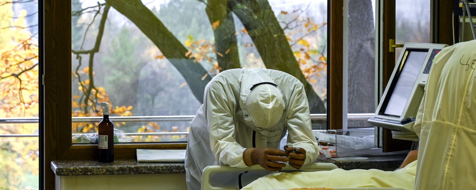 أحد أعضاء الطاقم الطبي يستريح بجانب مريض مصاب بفيروس كوفيد-19 في وحدة العناية المركزة في مستشفى لوزينيتس في صوفيا، بلغاريا 9 نوفمبر 2021. - سبوتنيك عربي, 1920, 13.07.2022