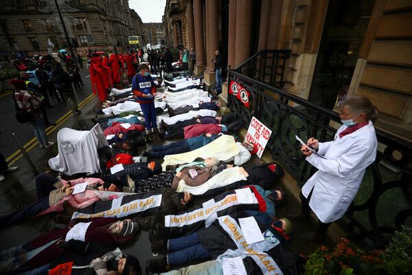 نشطاء تمرد ضد الانقراض ينظمون احتجاجًا يموتون أمام مبنى ميرسر، خلال مؤتمر الأمم المتحدة لتغير المناخ (COP26) في غلاسكو، اسكتلندا، بريطانيا، 8 نوفمبر 2021. - سبوتنيك عربي