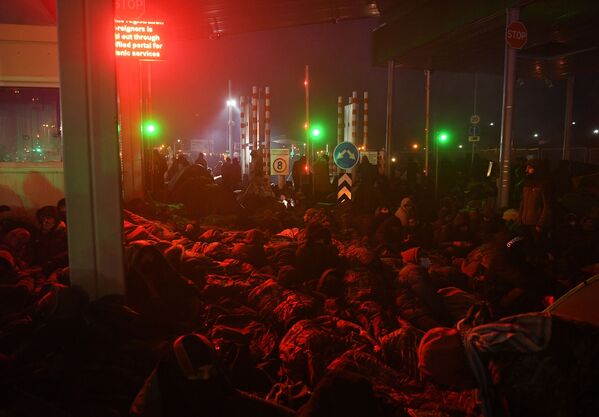 لاجئون من الشرق الأوسط نينامون على الأرض في نقطة تفتيش في بروزجي على الحدود البيلاروسية البولندية، 15 نوفمبر 2021 - سبوتنيك عربي