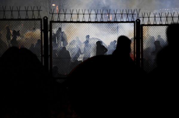 لاجئون من الشرق الأوسط يقفون بالقرب من السياج في نقطة تفتيش في بروزجي على الحدود البيلاروسية البولندية. في 8 نوفمبر 2021 - سبوتنيك عربي