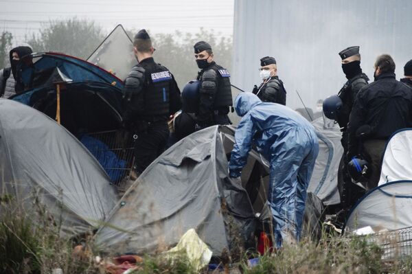 قوات الشرطة الفرنسية تقوم بعمليات تفتيش في المخيم المؤقت للمهاجرين في غراند سينث، شمال فرنسا، 16 نوفمبر 2021 - سبوتنيك عربي