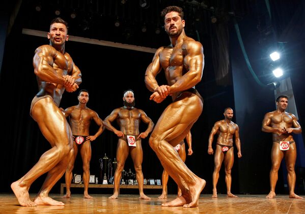 المشاركون يستعرضون عضلاتهم خلال مسابقة كمال الأجسام سيد كشمير في سريناغار، الهند 14 نوفمبر 2021. - سبوتنيك عربي