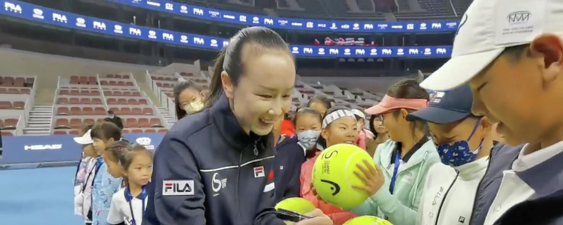 لاعبة التنس الصينية، بينغ شواي، توقع كرات تنس كبيرة الحجم في حفل افتتاح نهائي فيلا كيدز تنس جونيور في بكين، في أول ظهور لها بعد حادث اختفائها، 21 نوفمبر/ تشرين الثاني 2021 - سبوتنيك عربي, 1920, 23.11.2021